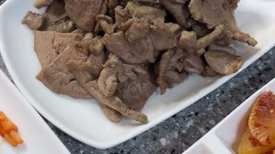 흰 접시에 수북이 담은 훈제오리 팽이버섯 볶음과 곁들인 밑반찬들