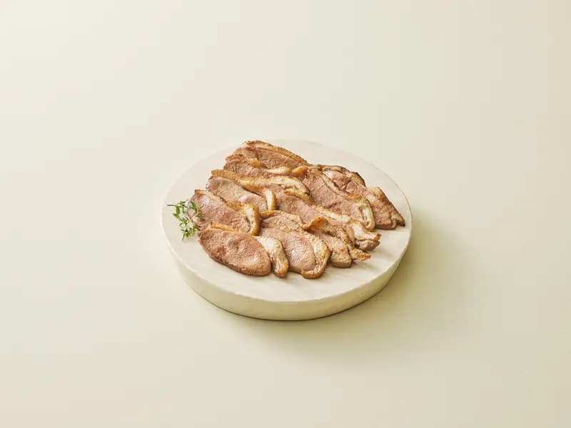 둥근 받침에 담긴 구운 훈제오리 슬라이스